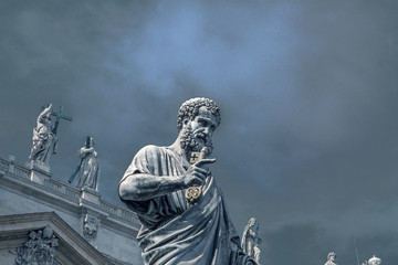 Fototapeta na wymiar Statue of St. Peter in front of St. Peter's Basilica on the background of a stormy sky