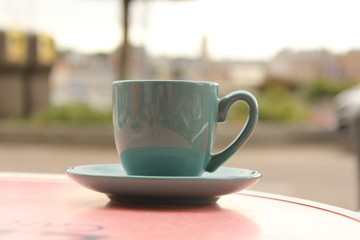 a mint green coffee cup closeup at a table outdoor