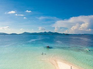 Aerial view of tropical  beach on island Ditaytayan. Beautiful tropical island with white sandy beach, palm trees and green hills. Travel tropical concept. Palawan, Philippines