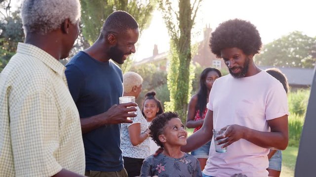 Family talking at a multi generation black family barbecue