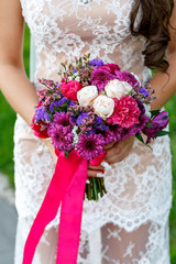 Bride Holding Wedding Bouquet with red ribbon