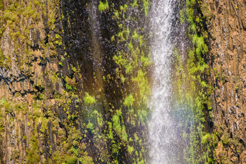Rainbow created by the water of Phantom Waterfall dropping off over vertical basalt walls, North Table Mountain Ecological Reserve, Oroville, California
