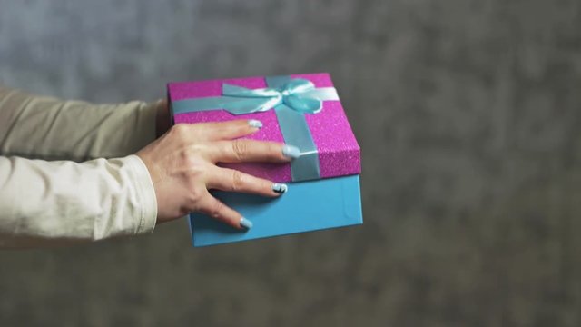 women's hands open a blue gift box and take out a white box with a telephone
