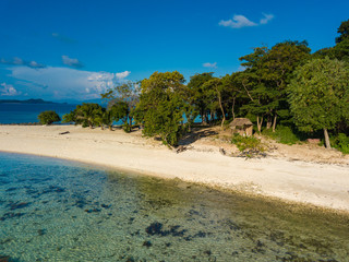 Aerial view of tropical  beach on island Ditaytayan. Beautiful tropical island with white sandy beach, palm trees and green hills. Travel tropical concept. Palawan, Philippines