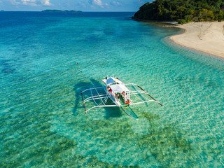 Aerial view of tropical  beach on island Ditaytayan. Beautiful tropical island with white sandy beach, palm trees and green hills. Travel tropical concept. Palawan, Philippines