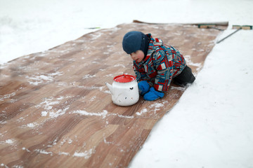 Boy playing curling with old kettles