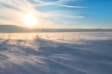 Sunset over hills covered with snow