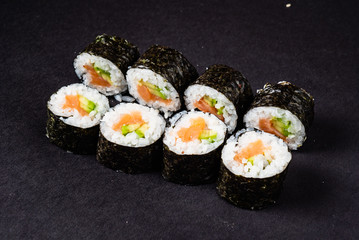 sushi with salmon and avocado on the black background