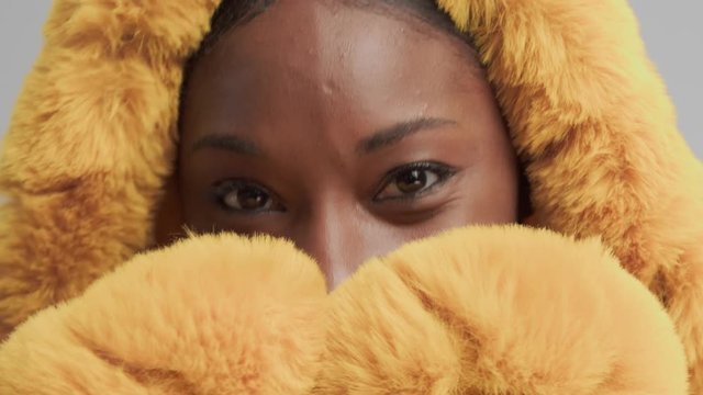 happu smiling blck mixed rase model wrapped in hood with fur