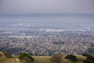 Aerial view of residential areas of San Jose, California on a rainy day; the city's financial district in the background;