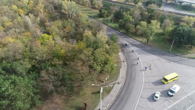 Shooting a running half-marathon athletes between the forest and the railway from a bird's eye view