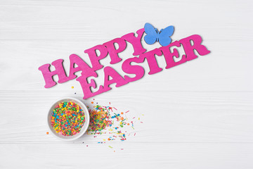 Bright colorful sugar sprinkles or confetti as baking decor with text happy easter