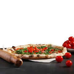 pizza margarita with cherry tomatoes and green on dark stone and isolated white background for copyspace