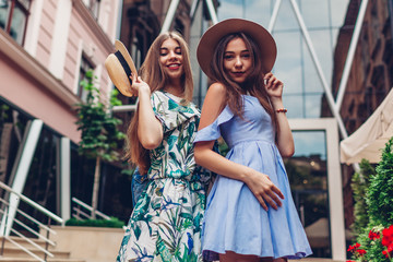 Outdoor portrait of two young beautiful women. Girls wearing stylish clothes and accessories in city. Best friends