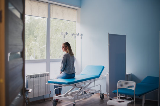 Waiting patient. A woman waiting for medical examination by sitting on treatment couch