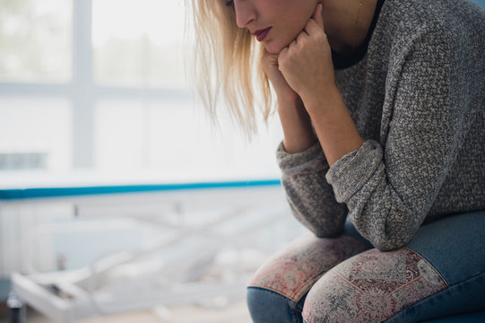 Waiting Patient. A Woman Waiting For Medical Examination By Sitting On Treatment Couch