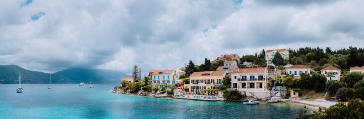 Superb scene of Fiskardo town with Zavalata Beach. Seascape of Ionian Sea on overcast day. Tranquil scene on Kefalonia island, Greece, Europe. Traveling vacation concept