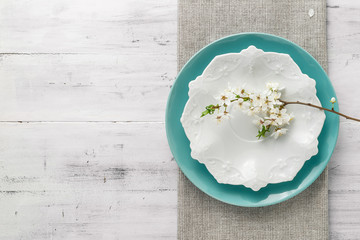 Spring table set with plates and white flowers