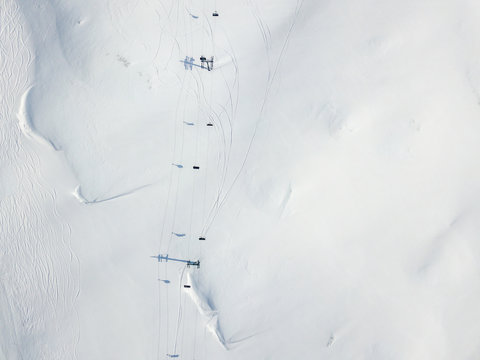 Aerial View Of Ski Chairlift On Snow Covered Mountain In Switzerland