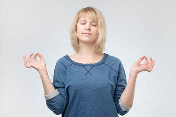 Young calm yogi woman practicing yoga, meditating with closed eyes, relaxing and working out.