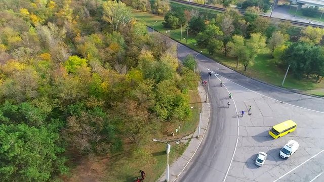 Shooting a running half-marathon athletes between the forest and the railway from a bird's eye view