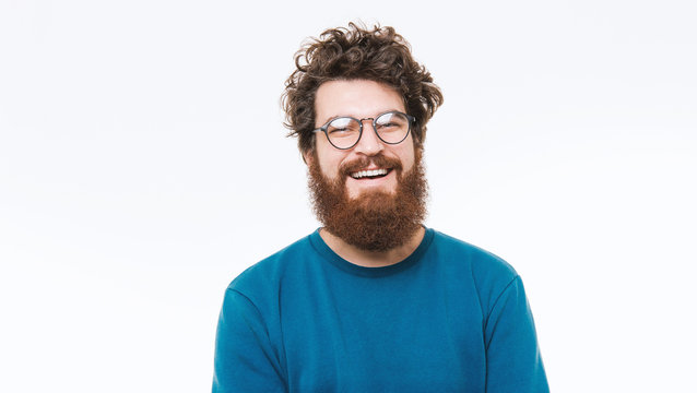 Portrait of smart  bearded man in blue sweater looking at camera and smiling