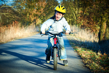 Boy riding his bike on a spring country track.  Road concept for safety and child development
