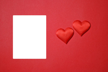 Two red hearts for Valentine's Day love on a red paper background