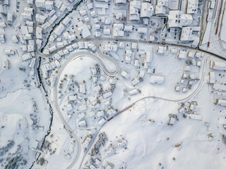 Aerial view of town with snow covered roofs. Village in Switzerland in winter with a lot of snow.