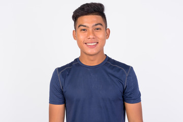 Young happy Asian man smiling against white background