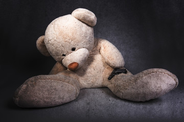 toy bear with a gun, suicide concept, toned  image on a concrete background