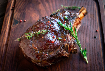 Grilled Ribeye Steak on bones on wooden board, prime cowboy steak