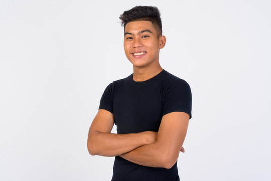 Young Happy Asian Man With Arms Crossed Against White Background