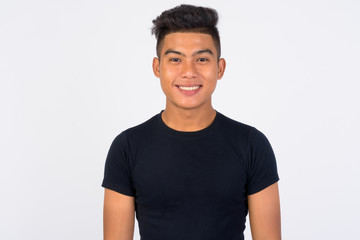 Young happy Asian man smiling against white background