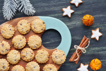 Christmas chocolate chip cookies, flat lay with spices and winter decorations on dark