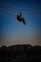silhouette of a man slack-lining a canyon