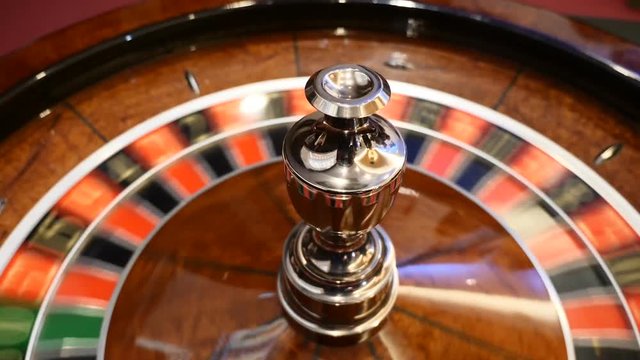 Casino theme. Top view on roulette in motion, white ball spinning. Bad luck and Good luck concept. Roulette wheel running. City nightlife entertainment. hd