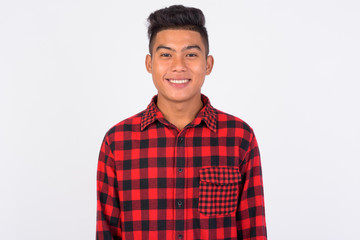 Young happy Asian hipster man smiling against white background