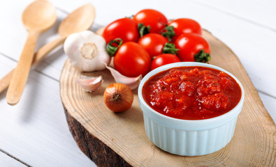 tomato sauce with garlic, basil and spices in a white bowl closeup.