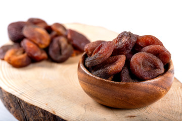 Organic Dried Apricots in bowl on wooden background