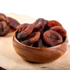 Organic Dried Apricots in bowl on wooden background