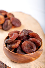Organic Dried Apricots in bowl on wooden background