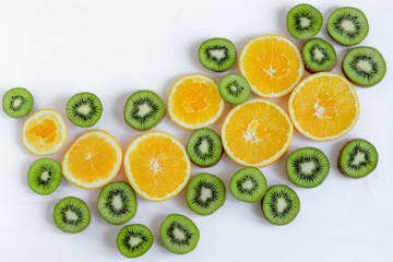 Pattern with oranges and kiwi slices on a white wooden background. The basis for the booklet, the background for the banner. Basis for design with tropical fruits