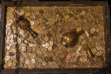 Top view of treasure chest full of gold coins, gold vase and pot