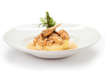 quail in a sauce with a side dish of mashed potatoes on a round white plate