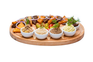 appetizer of assorted croutons and assorted sauces on an oval wooden Board