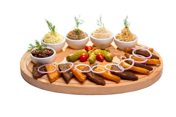 appetizer of assorted croutons and assorted sauces on an oval wooden Board