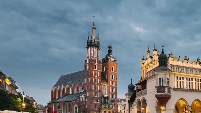 Krakow, Poland. Night View Of St. Mary's Basilica And Cloth Hall Building. Famous Old Landmark Church Of Our Lady Assumed Into Heaven. UNESCO World Heritage Site