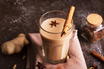 Masala chai tea on the dark background. Hot indian beverage with spices