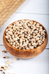 White kidney beans in bowl on wooden background.
